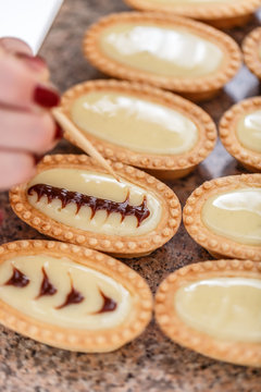 Woman hand decorating mini tarts