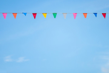 Colorful flag paper with blue sky and cloud background.