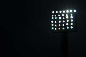 Fototapeta premium Reflektor stadionu piłkarskiego w nocy z ciemnym tłem.