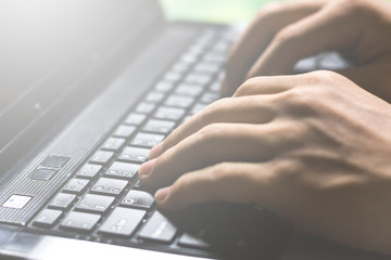 hands typing and searching for online education or information through laptop computer on vintage tone, selective focus