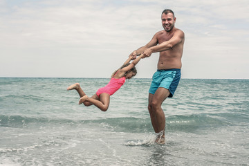 Father with his daughter on the beach. Father and daughter having fun on the beach.