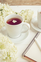 Morning breakfast with a cup of tea or coffee and a blank notebook on a white background