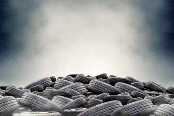 pile of used rubber tires with fox or smog background. dark tone and over light