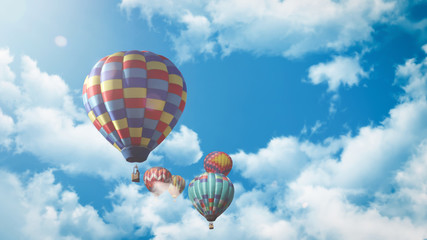 Fototapeta na wymiar Mehrere Heißluftballons fliegen vor einem blauen bewölkten Himmel bei Sonnenuntergang 