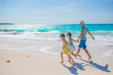 Family on white tropical beach have a lot of fun. Father and kids enjoy holidays on the seashore. Beach vacation activity