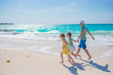 Naklejka premium Family on white tropical beach have a lot of fun. Father and kids enjoy holidays on the seashore. Beach vacation activity
