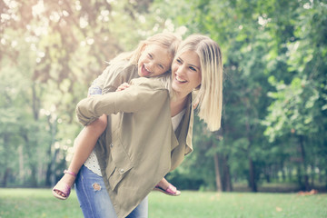 Little girl on a piggy back ride with her mother.