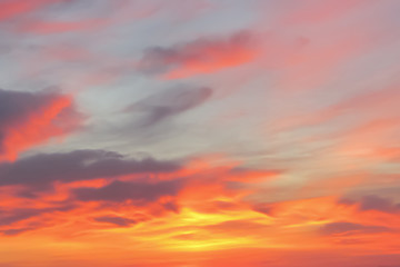 Naklejka na ściany i meble Bright orange, pink and dark clouds in the sky at sunrise or sunset