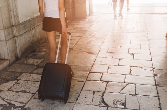 Woman pulling wheeled suitcase bag