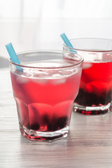 Berry drink of red color with currant and ice in a glass. The sweaters are saved with a cocktail.