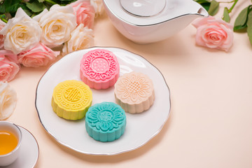 Sweet color of snow skin mooncake. Traditional mid autumn festival foods with tea on table setting.