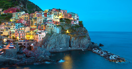 Fototapeta na wymiar Magical beautiful landscape with bright colored houses on the rock on the sea coast of Manarola in Cinque Terre, Liguria, Italy, Europe in the evening