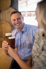 Couple interacting with each other while having beer in bar