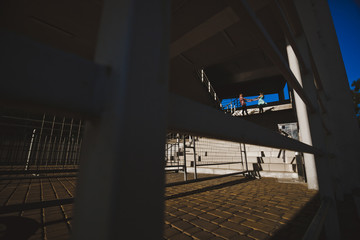 парень и девушка держатся за руки стоя на лестнице и перил на фоне неба