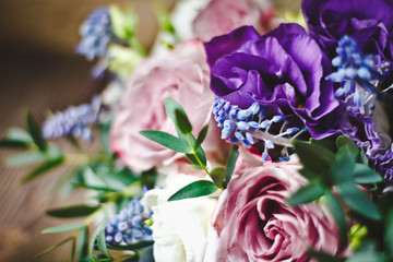 красивый свадебный букет с фиолетовыми розовыми и голубыми цветами на на нейтральном фоне