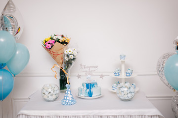 торт, букеты и кэнди-бар на фоне стены и воздушных шариков