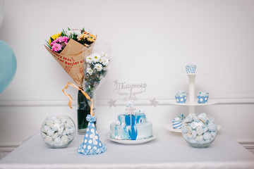 торт, букеты и кэнди-бар на фоне стены и воздушных шариков