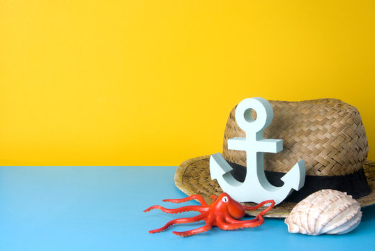 vintage rattan hat and octopus and anchor and shell on colorful background in summer concept