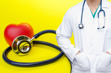smart doctor with a stethoscope around his neck with red heart and a stethoscope on yellow background, heart health care and medical technology concept, selective focus.