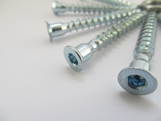 Silver gray bolts are placed on the right side on a white background, an option for letter or...