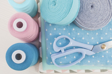 Sewing kit. Thread blue, pink, beige, cloth fabric, scissors,rolls ribana grey and menthol