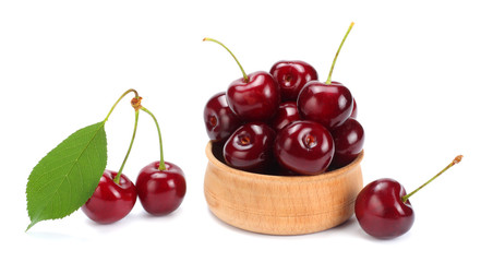 cherries in wooden bowl isolated on white background.