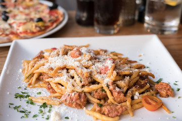 Pasta with Tomato sauce, Sprinkling Cheese. On plate in the restaurant.