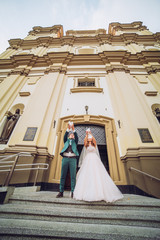 Wedding pigeons in hands of the groom and the bride. Newlyweds near church.