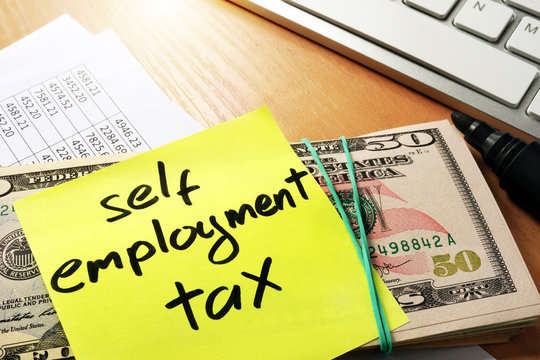 Self employment tax written on a memo stick.