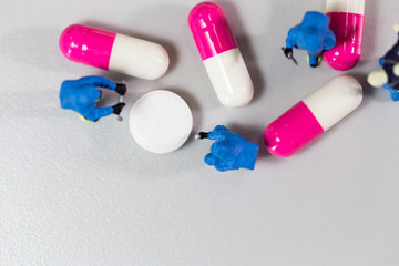 Miniature people with Medicine research.