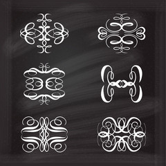 Set of elegant calligraphic elements on a chalkboard background.