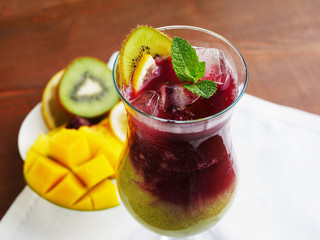 Crushed ice cocktail, slush with mixed summer fruits in glass