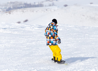 Fototapeta na wymiar Snowboarder snowboarding in the snow in winter