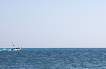 Fototapeta premium Motor boat heading towards the sea. Nothing more but empty horizon. Boat composed to the left where the focus point is. Copy space.