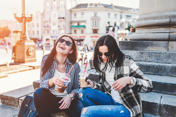 Fototapeta na wymiar Two long hair brunette girls talking and drinking coffee outdoor