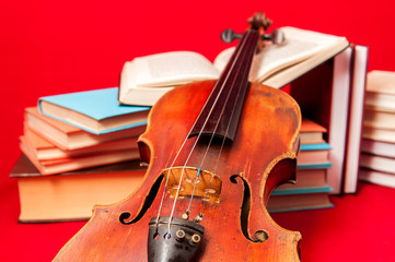 Music instrument old violin on a book and pile of books