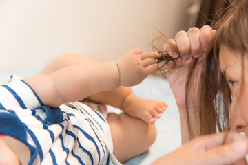 ママの髪の毛を引っ張る赤ちゃん
