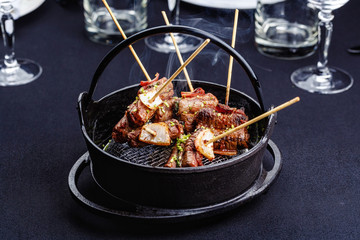 Meat on skewers smoks in a brazier