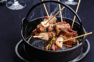 Meat on skewers smoks in a brazier