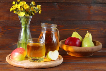 Apple juice and fruit on a dark wooden background.
