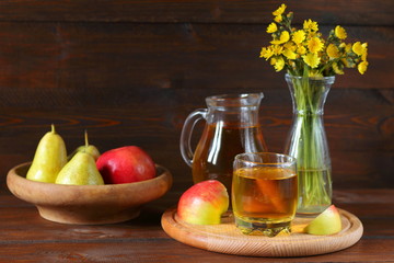 Apple juice and fruit on a dark wooden background.