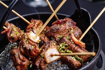 Meat on skewers smoks in a brazier