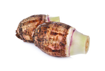 whole unpeeled raw taro on white background