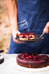 Fruit berry cake. Person serving blueberry raspberry slices of cake. 