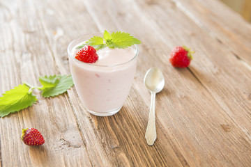 Homemade fresh yoghurt with strawberries on wooden table