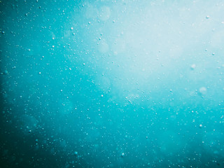 Naklejka na ściany i meble Water bubbles in underwater in blue ocean. Water texture.