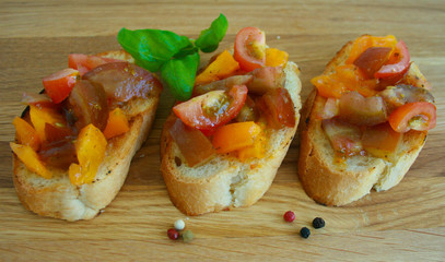Tasty tomato Italian bruschetta on toasted slices of baguette seasoned with spice and herbs and garnished with fresh basil 