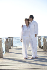 couple amoureux qui marche sur un ponton sur la mer