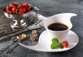 Wild strawberries and cup of black coffee