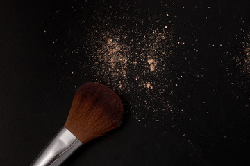Closeup a buffing brush and some powder foundation on black background